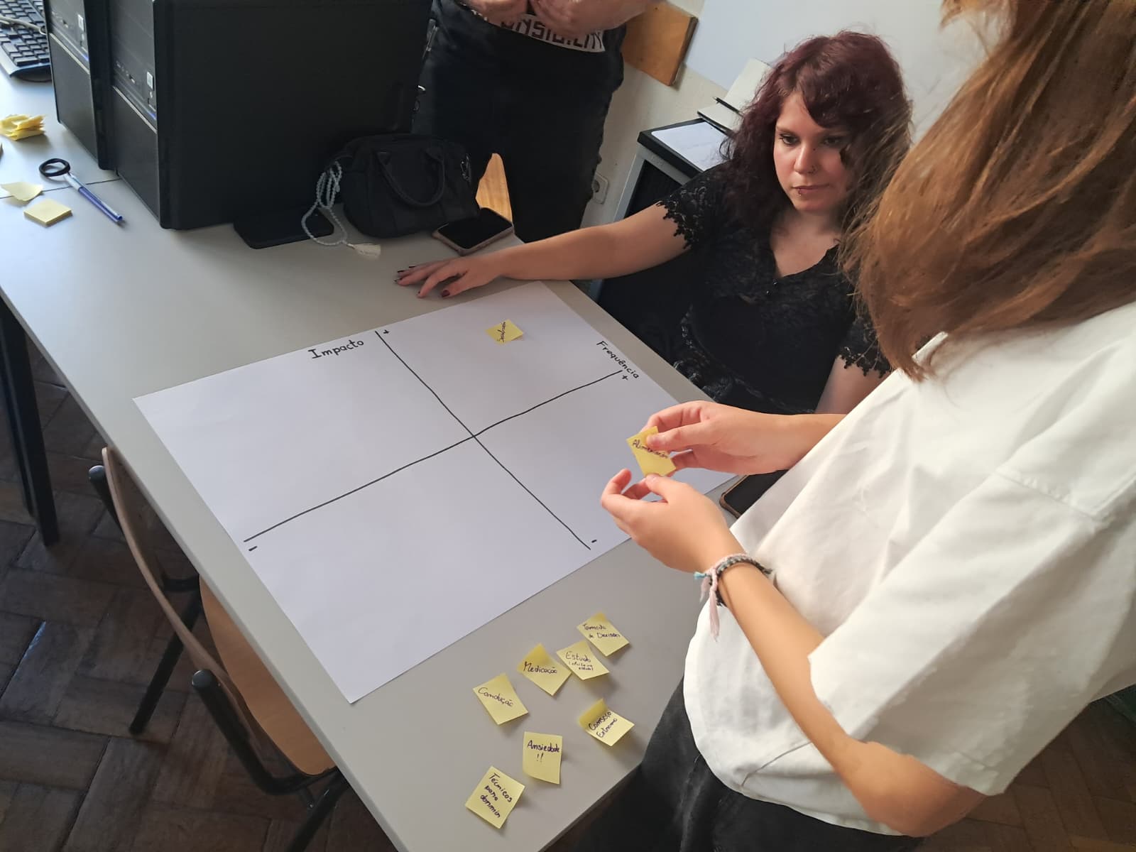 The co-designer and a teammate work through an evaluation matrix.